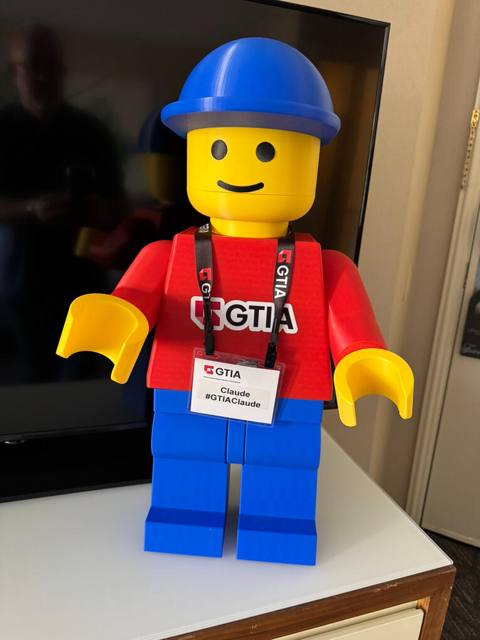 A custom two-foot printed figure wearing a conference badge